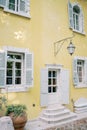 Yellow facade of an ancient villa with white shutters on the windows and a lantern above the entrance Royalty Free Stock Photo