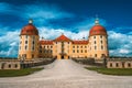 Yellow Facade of Castle Moritzburg with orange roof, Saxony, Dresden, Germany. Beautiful spring day with blue sky and