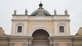 Yellow facade of Church on background cloudy sky. Action. Beautiful details of facade of Catholic Church in yellow with
