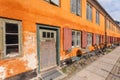 Yellow facade of old building in traditional style in Copenhagen, Denmark. Bicycle parked at door of colorful house