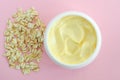 Yellow facial cream hair mask, body butter in a small white container and oatmeal. Natural skin and hair concept. Top view Royalty Free Stock Photo