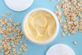 Yellow facial cream hair mask, body butter in a small white container and oatmeal. Natural skin and hair concept. Top view Royalty Free Stock Photo