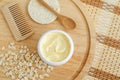 Yellow facial cream (hair mask  body butter) in a small white container and oatmeal. Natural skin and hair concept. Royalty Free Stock Photo