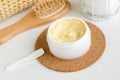 Yellow facial mask banana face cream, shea butter hair mask, body butter in the small white jar. Natural skin and hair concept. Royalty Free Stock Photo