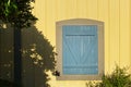 Yellow farm building blue barn door shadows Royalty Free Stock Photo