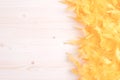 Yellow feather boa on light board on the left with space for tex Royalty Free Stock Photo