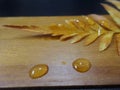 Yellow fern leaves and water drops on woodenbackground