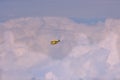 Yellow firefighting aircraft in the clouds