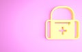 Yellow First aid kit icon isolated on pink background. Medical box with cross. Medical equipment for emergency