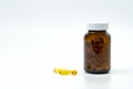 Yellow fish oil capsule pills with amber glass bottle with blank Royalty Free Stock Photo