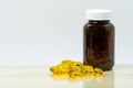 Yellow fish oil capsule pills with amber glass bottle with blank Royalty Free Stock Photo