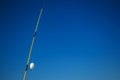 Yellow fishing pole and white float on background of blue sky