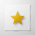 A yellow, five-pointed star is centrally placed on a white square paper against a neutral background Royalty Free Stock Photo
