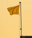 Yellow flag against a blue sky Royalty Free Stock Photo