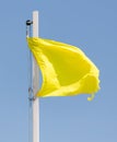 A yellow flag against a blue sky Royalty Free Stock Photo