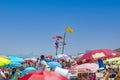 Yellow flag installed on top of lifeguard seat on the beach full of people Royalty Free Stock Photo