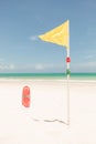 Yellow flag and red plactic lifeguard tube Royalty Free Stock Photo