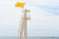 Yellow flag tower on a beach, indicating swimming caution Royalty Free Stock Photo