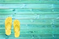 Yellow flip flops on blue planks, summer concept background
