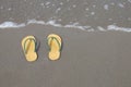 Yellow flip-flops footware pair on the beach sand Royalty Free Stock Photo
