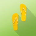 Yellow flip-flops on a green background. Flat lay summer background