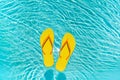 Yellow Flip Flops floating in a clear blue swimming pool water