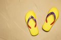 Yellow flip flops on sand. Beach accessory