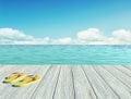 Yellow flip flops on a wooden floor by the seashore