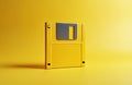 Yellow floppy disk on plain yellow background with soft shadow. This vintage data storage medium represents old tech and digital Royalty Free Stock Photo