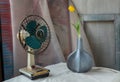 Yellow flower in Blue wooden vase and Vintage fan on white textured table cloth with old cement wall Royalty Free Stock Photo