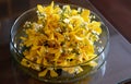 Yellow flowers floating in glass bowl vase on glass top table in Royalty Free Stock Photo