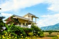 Yellow flowers foreground with beautiful home behind and blue sky in the top Royalty Free Stock Photo