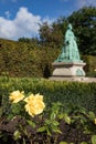 Yellow Flowers With Green Statue in Background