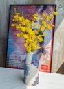 Yellow flowers in Handmade ceramic vase and with Classic chinese poster movie frame with old ruins cement wall