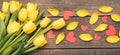 Yellow flowers seen from above. Lay flat on boards. Tulip petals and red hearts from paper. Panoramic view. Royalty Free Stock Photo