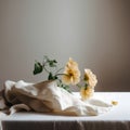 Yellow flowers on a white tablecloth with a gray wall in the background