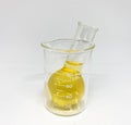 Yellow fluid in glassware beaker with white background