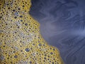 Yellow foam in a deep gray dirty water. Pollution and sadness. Royalty Free Stock Photo