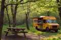 A yellow food truck is parked among the trees in a wooded area, providing refreshments and meals to visitors, Food truck at a