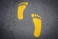 Yellow footprint signs on an asphalt road