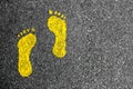 Yellow footprints on asphalt