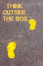 Yellow footsteps on sidewalk towards Think Outside The Box message