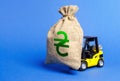 Yellow forklift carries a money bag with Ukrainian hryvnia symbol. Concept of a major contract, profitable deposit or loan. Royalty Free Stock Photo