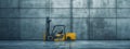 A yellow forklift is parked by a concrete wall in a warehouse Royalty Free Stock Photo