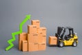 Yellow Forklift truck brings the box to a stack of boxes and a green arrow up. raise economic indicators. exports, imports. sales Royalty Free Stock Photo