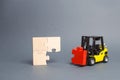 The yellow forklift truck brings the missing red puzzle to the unfinished construction. Completion of project, a key element Royalty Free Stock Photo