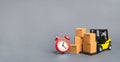 Yellow Forklift truck with cardboard boxes and a red alarm clock. Express delivery concept. Temporary storage, limited offer