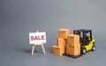 Yellow Forklift truck with cardboard boxes and stand with the word sale. sale of goods, big discounts on goods of the outgoing