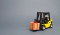 Yellow forklift truck carries a gift with a red bow. Purchase and delivery of a present. retail, discounts and contests Royalty Free Stock Photo