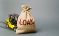 Yellow forklift truck crashed into the bag with the word loan and can not lift it. Inability to repay a loan, debt restructuring